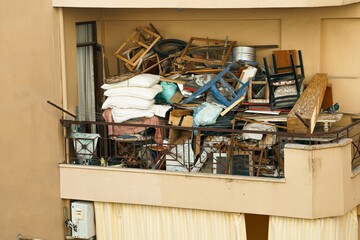 Ugly, terrible balcony disorder. Multi-storey building full of garbage, old furniture, unnecessary...