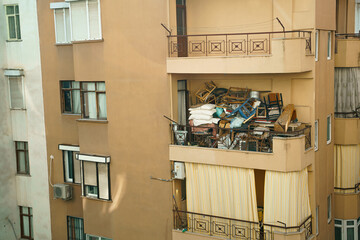 Ugly, terrible balcony disorder. Multi-storey building full of garbage, old furniture, unnecessary...