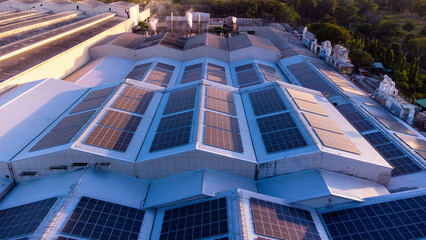 Fly over Solar cells on the roof of a large industrial factory. Solar roofs are generating...