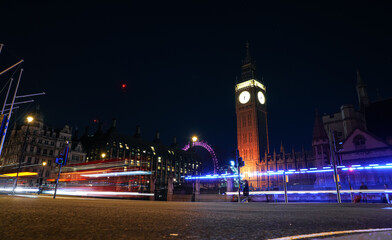 Fototapeta na wymiar Travel to London. Big Ben Clock Tower photographed during the night with long exposure, traffic lights in front of it.