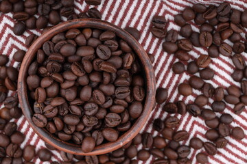 Coffee beans are scattered on the fabric. a close-up photo of freshly roasted coffee of high quality. top view