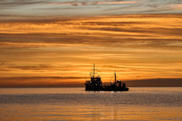 Fishing boat at sunrise or sunset