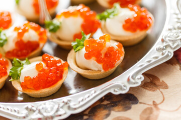 canape with caviar on silver tray