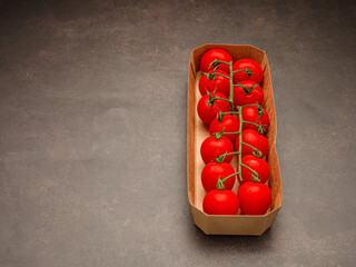 Beautiful red ripe fresh cherry tomatoes in a box on a vintage background