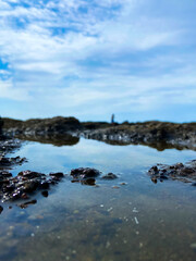 岩にできた水溜りと青空