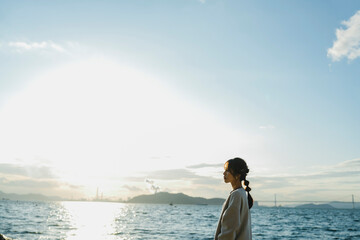 海で夕日を見ている女性