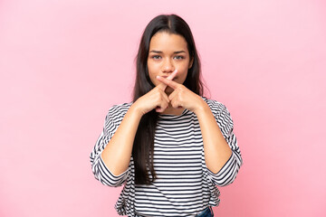 Young Colombian woman isolated on pink background showing a sign of silence gesture