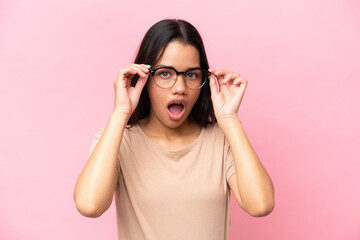 Young Colombian woman isolated on pink background With glasses and surprised expression
