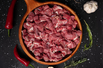Chopped raw meat. Cut beef into small pieces on wooden plate