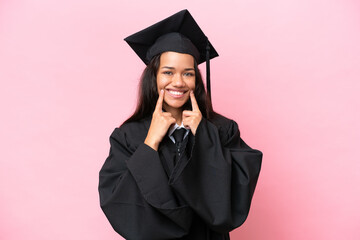 Young university Colombian woman graduate isolated on pink background smiling with a happy and...