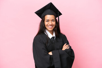 Young university Colombian woman graduate isolated on pink background with arms crossed and looking...
