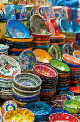 Fototapeta na wymiar Stack of classical traditional Turkish ceramics, handmade colorful dishes at the Istanbul Egypt Bazaar (Misir Carsisi). Istanbul, Turkey souvenirs. Selected focus, copy space