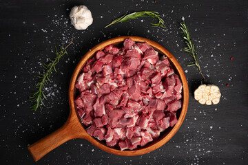 Chopped raw meat. Cut beef into small pieces on wooden plate