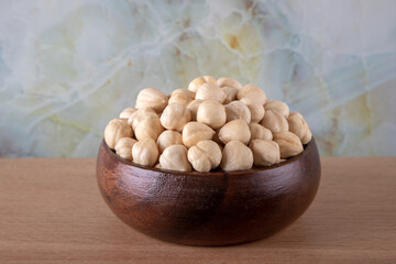 Bowl full of hazelnuts on wooden background
