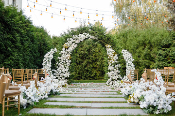 Place for wedding ceremony in garden outdoors, copy space. Wedding arch decorated with flowers. Wedding setting.Place for wedding ceremony in garden outdoors, copy space. Wedding arch 