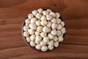 Bowl full of hazelnuts on wooden background
