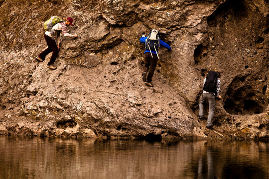 Three males climbers work their way across the Rock Pool traverse at Malibu Canyon State Park in Malibu, California.