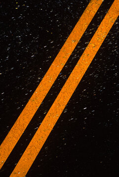 Rain Falling On Double Yellow Road Stripes, California.