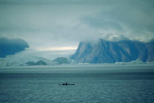 An Inuit hunter stalks Narwhal from his sea kayak.