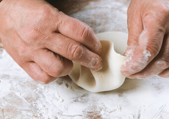 Fototapeta premium Chef cook making dumplings, manti, khinkali on wooden table. Process preparation georgian meal. food concept.