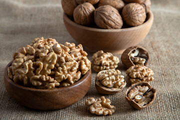 Peeled walnuts and whole walnuts on burlap sack