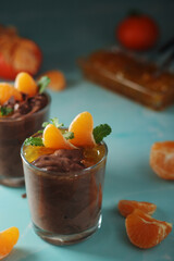 Chocolate mousse dessert with tangerines in glasses