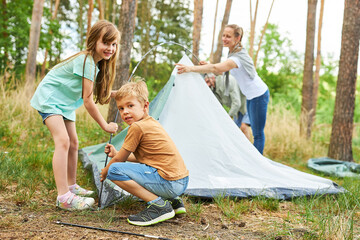 Family setting up tent for camping during vacation © Robert Kneschke