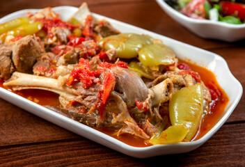 Khashlama is popular Armenian dish, which is prepared from beef with vegetables. Khashlama in the plate. stewed lamb on the bone with vegetables on wooden desk