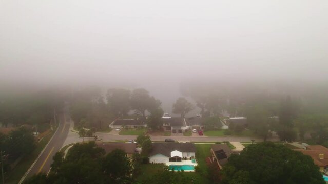 Aerial flyover through foggy and misty neighborhood in city of Ocoee, Florida with no vehicles driving.  Ocoee is a family oriented town with many neighborhoods.