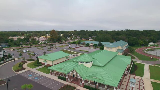 Reverse aerial flyover of the charming and quaint city of Ocoee town hall in Central Florida with nobody outside.  Ocoee is a family oriented town with restaurants, breweries, bars, and shopping.