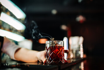 man hand bartender making cocktail glass in bar with smoke