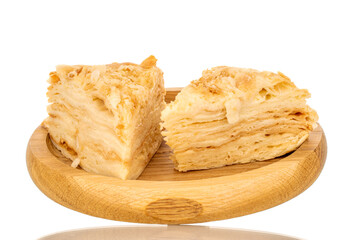 Two pieces of cream cake on a wooden tray, macro, isolated on white background.