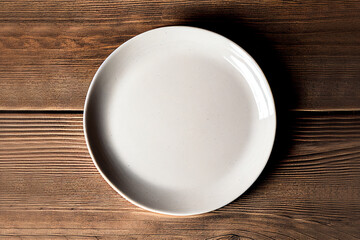 Top view empty blank ceramic round white plate on wooden brown background.