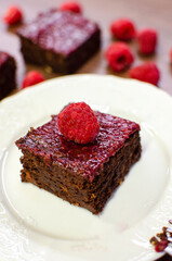 Fototapeta na wymiar Chocolate brownies with raspberries on white plate 