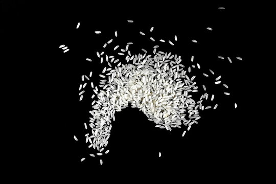 Rice spilled on a black background. Raw white rice explosion isolated on white background. 