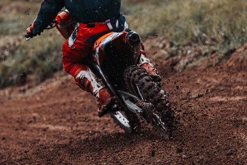 Motocross, pieces of dirt flying off the bike, off-road motorbike races, rear view