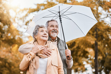Senior couple, umbrella and walking outdoor for relax freedom, calm quality time and relationship bonding in summer. Elderly man, woman and wellness walk in countryside park together for love or care