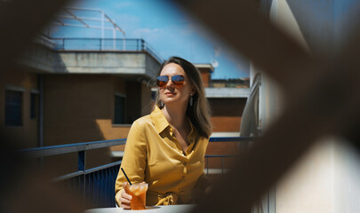 Fototapeta premium Woman enjoys the summer while sitting on the balcony.