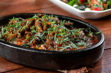 Oriental cuisine:  meat with vegetables and onion in a bowl close-up on the table.