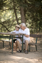 Happy senior man Grandfather with cute little boy grandson playing in forest