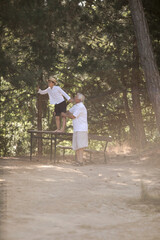 Fototapeta premium Happy senior man Grandfather with cute little boy grandson playing in forest