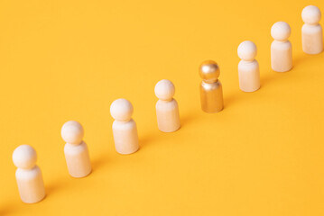 An employee figurine comes out of a row of colleagues. Promotion at work, appointment to the role of team leader. Dismissal of an employee. Take the first step, be different. Initiative and aspiration