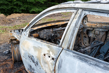 Spalony samochód na parkingu w lesie - obrazy, fototapety, plakaty