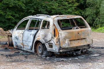 Spalony samochód na parkingu w lesie