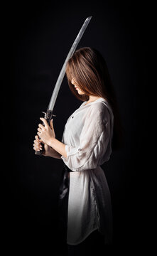 Beautiful asian lady with katana sword. Ninja samurai female warrior concept. Vertical studio photography.