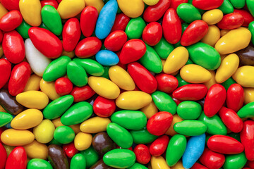 Fototapeta na wymiar Candy in multi colored glaze in bulk, mini pieces, wallpaper background