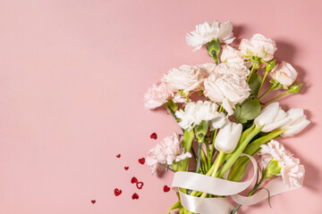 Valentine's Day greeting card with beautiful flowers and hearts on pink background. Valentine's day, Womans day, wedding, birthday or mothers day. View from above. Copy space.