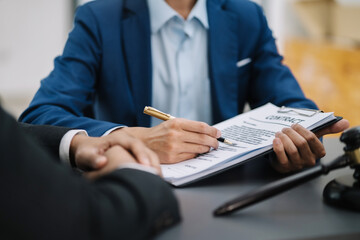 Lawyer signing important legal document on desk at office.