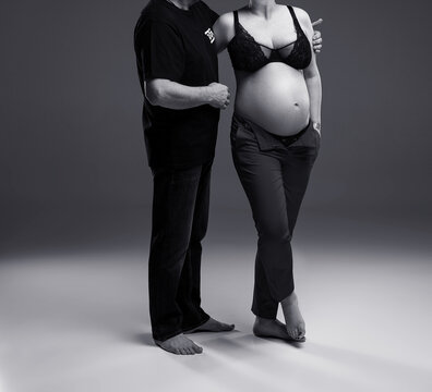 pregnant woman with her husband posing in studio, studio pregnancy shoot, pregant couple, black and white photo
