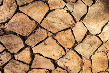 Beige, brown stone surface. The texture of the stone floor. Road paved with stone tiles.